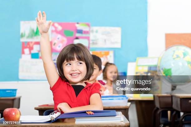 encantadores une poco estudiante plantear mano en elemtary con montaje tipo aula - alzar la mano fotografías e imágenes de stock