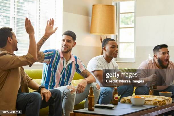 male fans supporting different teams watching match - friendly match photos et images de collection