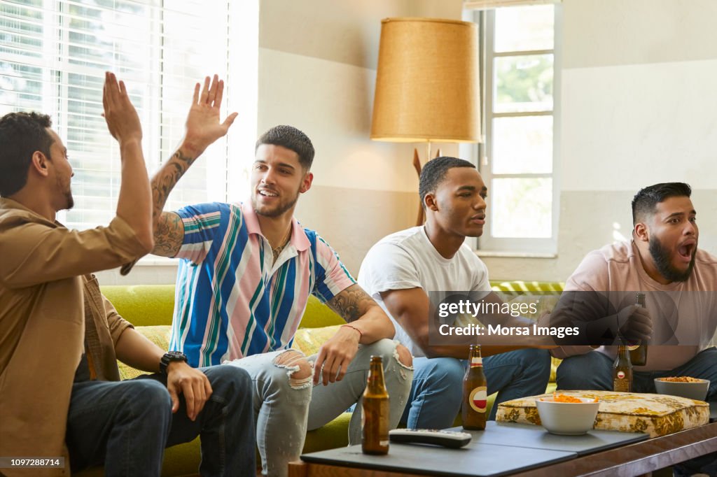 Male fans supporting different teams watching match