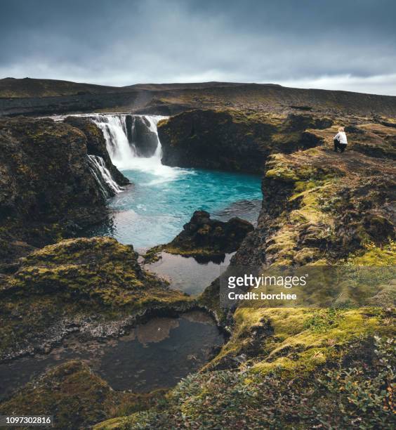 woman admiring waterfall in iceland - central highlands iceland stock pictures, royalty-free photos & images