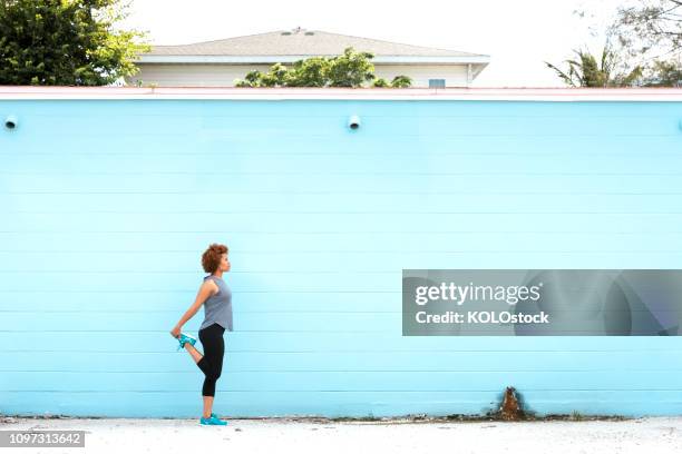 young woman stretching leg - quadriceps muscle stock pictures, royalty-free photos & images