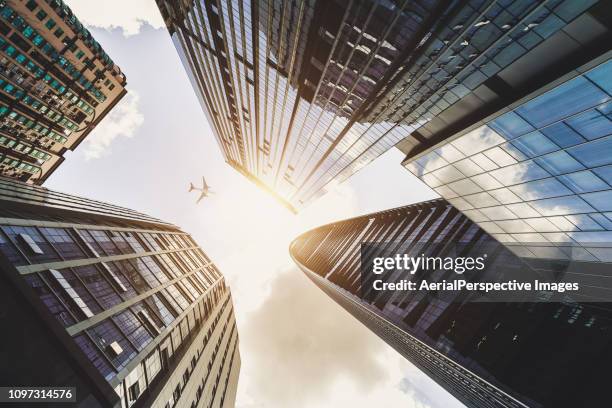 airplane flying over city business buildings - airplane front view stock pictures, royalty-free photos & images