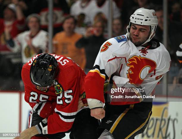 Mark Giordano of the Calgary Flames throws a punch at Viktor Stalberg of the Chicago Blackhawks in the 2nd period at the United Center on March 2,...