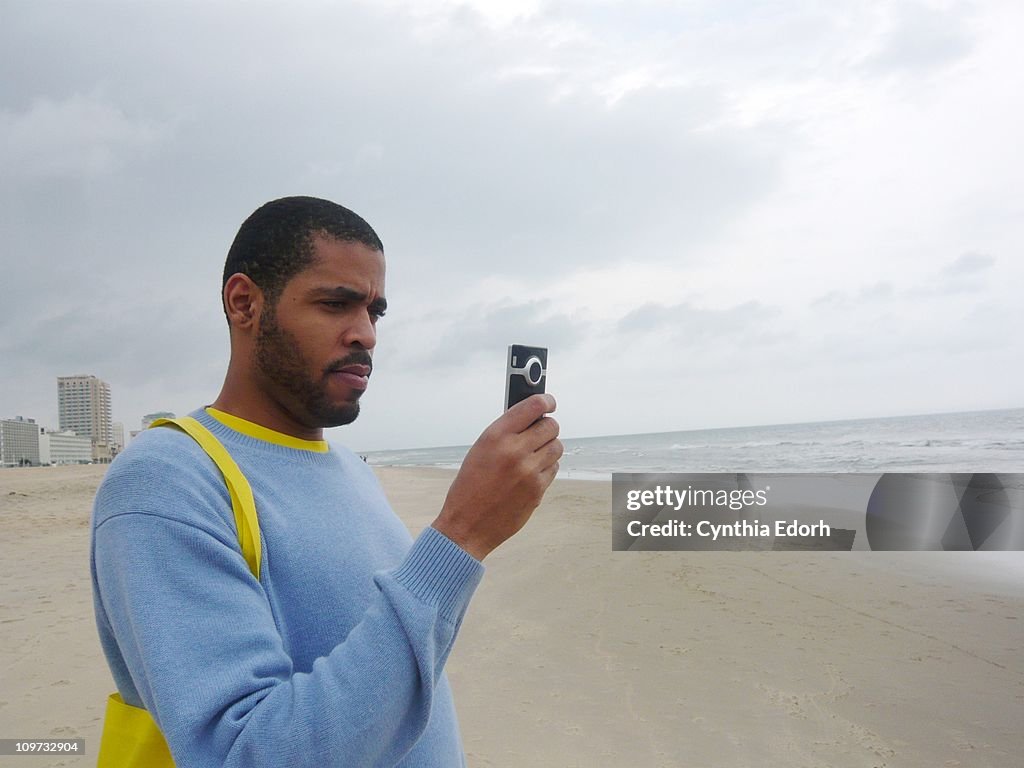 Young man filming with video camera