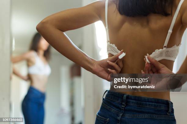 jonge vrouw haar beha sluiten - beha stockfoto's en -beelden