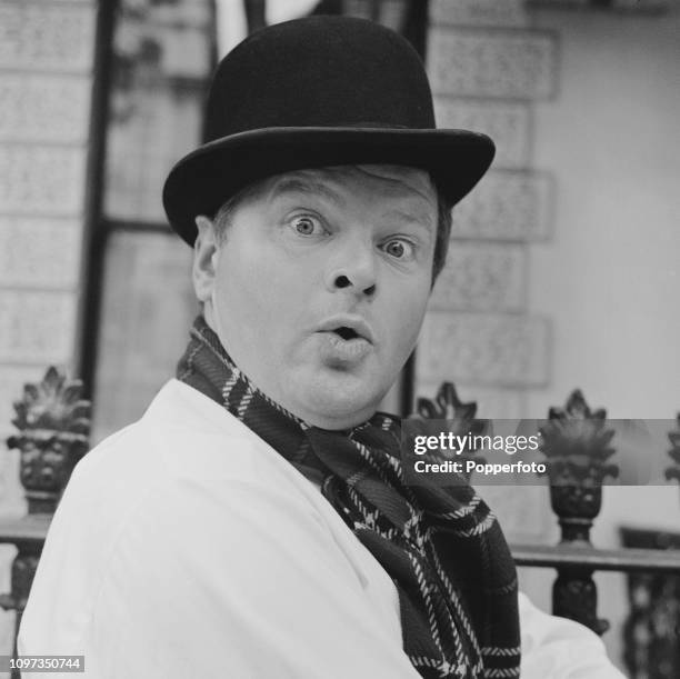 English comedian and actor Benny Hill pictured standing outside his apartment on Queen's Gate in South Kensington, London in October 1962.