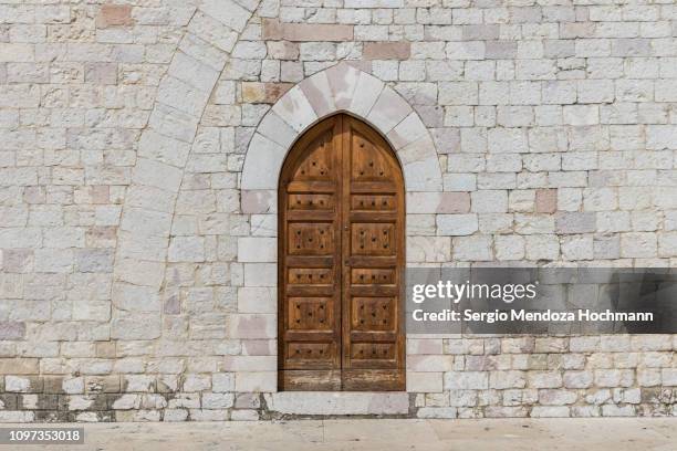 a wooden door in the basilica of st. francis - assisi, italy - brick cathedral stock pictures, royalty-free photos & images