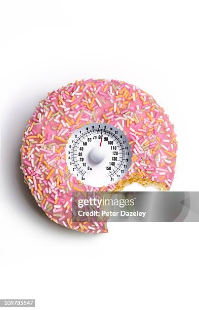 doughnut with bite out and weighing scales - pink donut stock pictures, royalty-free photos & images