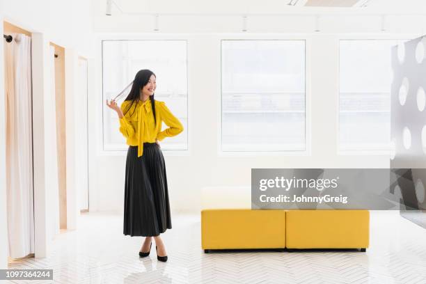 full length of chinese woman in modern shop - johnny stark stock pictures, royalty-free photos & images