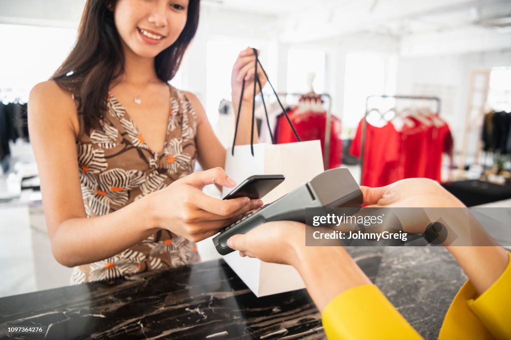 Young woman paying contactlessly