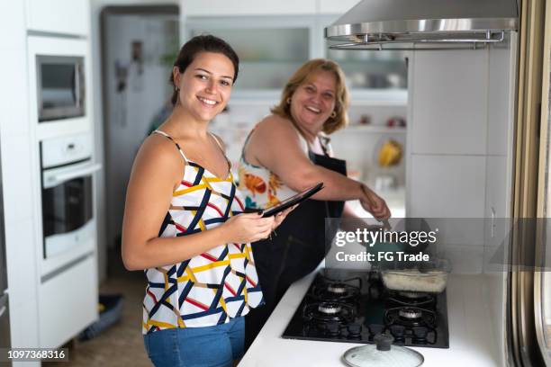 daughter and mother cooking together at home - daily life in sao paulo stock pictures, royalty-free photos & images