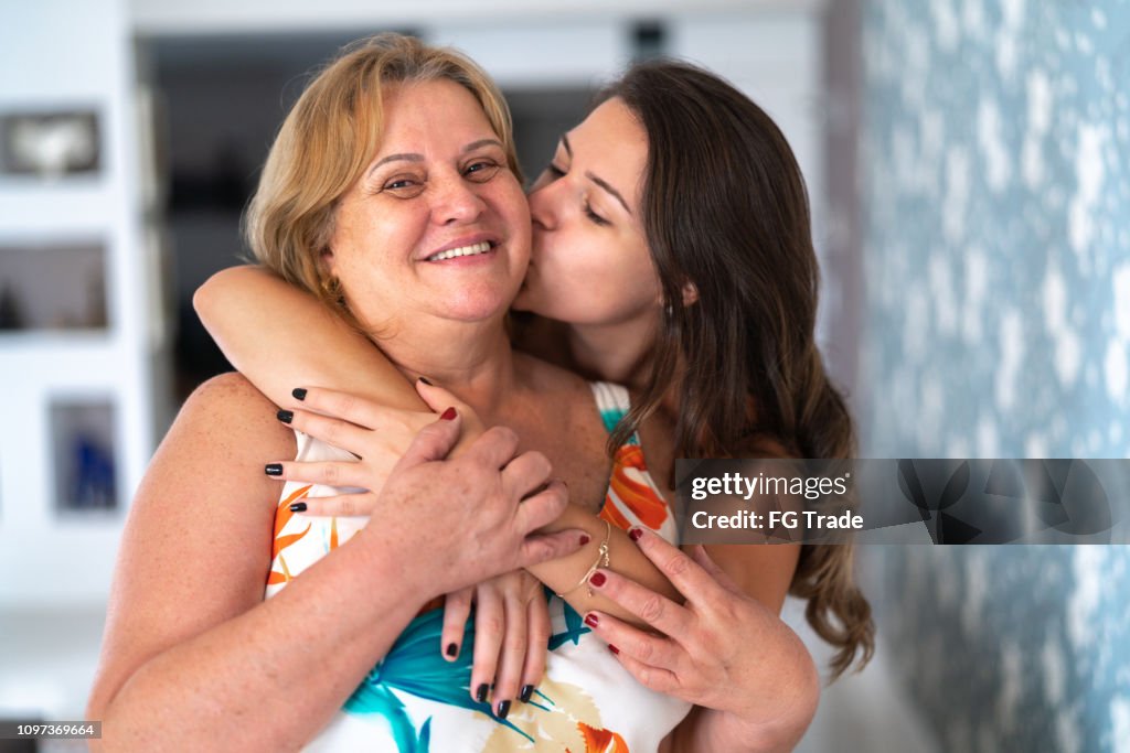 Filha e mãe abraçando em casa