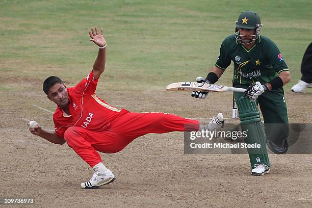 Harvir Baidwan of Canada gathers the ball and aims to run out Misbah-ul-Haq as Umar Akmal backs up during the Canada v Pakistan 2011 ICC World Cup...