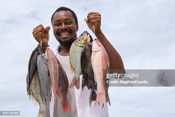 fisherman with fresh fish - seychelles stock pictures, royalty-free photos & images