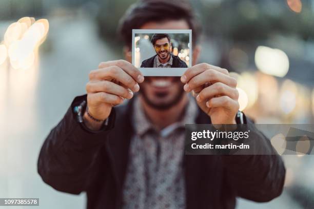 young man showing instant self-portrait - holding photo stock pictures, royalty-free photos & images