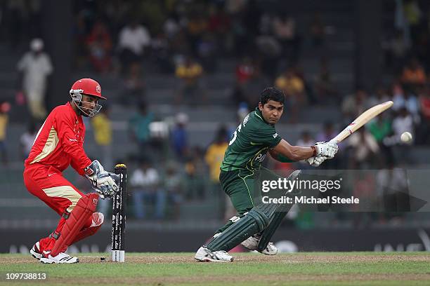 Umar Akmal of Pakistan plays to the offside as wicketkeeper Ashish Bagai looks on during the Canada v Pakistan 2011 ICC World Cup Group A match at...