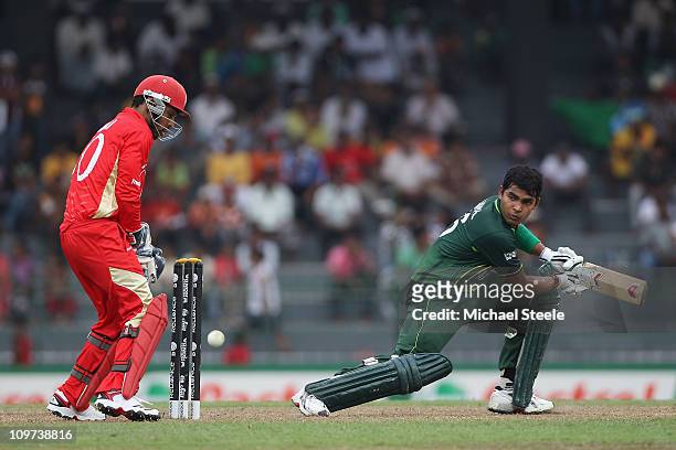 Umar Akmal of Pakistan plays to the offside as wicketkeeper Ashish Bagai looks on during the Canada v Pakistan 2011 ICC World Cup Group A match at...