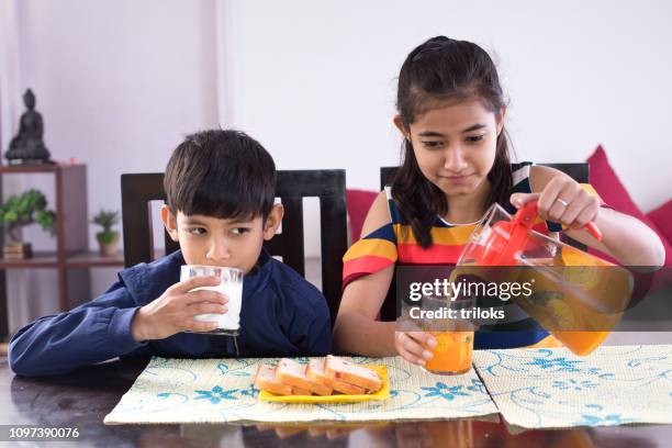 broer/zus ontbijten - family orange juice stockfoto's en -beelden