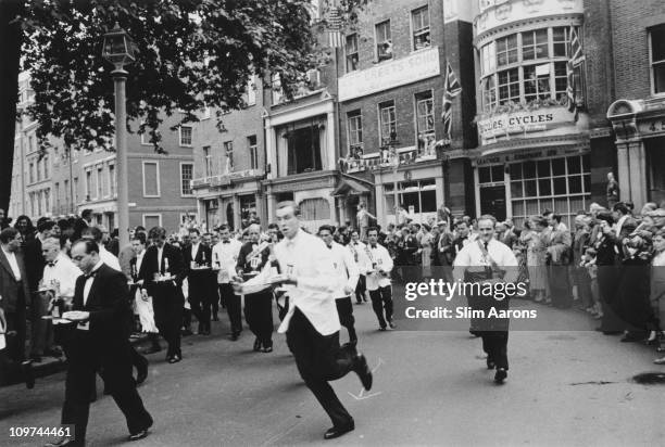 Waiters carrying half bottles of champagne set off on the annual waiters' race from Soho Square to Greek Street, in London's Soho, 1955.