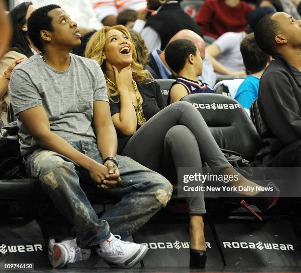New York Nets shareholder Jay-Z, with wife Beyonce at his side, watches as the Nets lose to the Phoenix Suns in overtime at the Prudential Center.