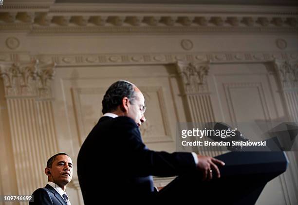 President Barack Obama listens while Mexican President Felipe Calderon speaks during a joint news conference in the East Room of the White House...