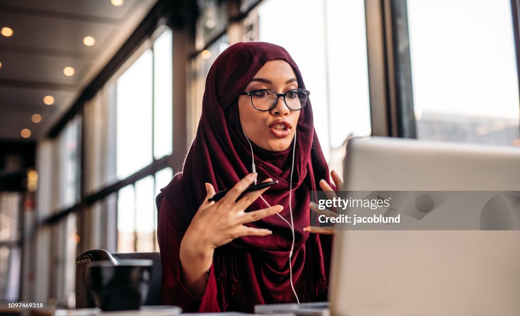 Businesswoman in hijab having a video chat on laptop