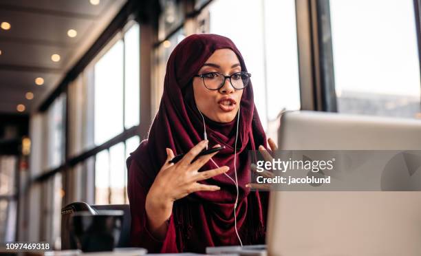 Businesswoman in hijab having a video chat on laptop