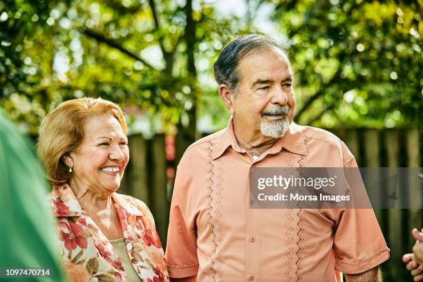 smiling senior couple looking away in party - miami party stock pictures, royalty-free photos & images