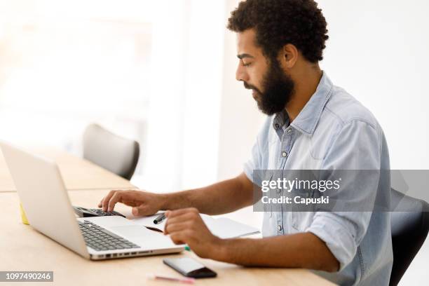 zwarte man die op laptop werkt - pardo stockfoto's en -beelden