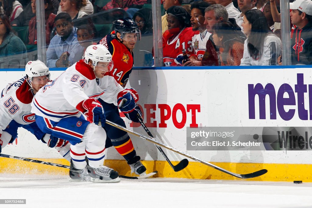 Tom Pyatt of the Montreal Canadiens digs the puck out from the boards ...