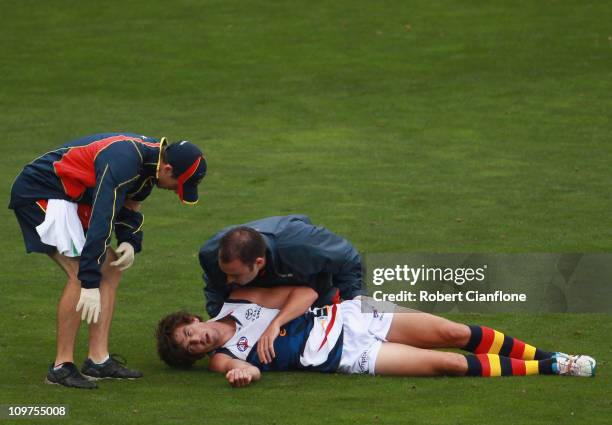 Ricky Henderson of the Crows is treatd by medical staff after he was knocked out during the NAB Challenge AFL match between the Carlton Blues and the...