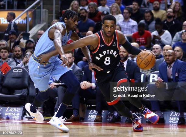 Jordan Loyd of the Toronto Raptors dribbles the ball as Justin Holiday of the Memphis Grizzlies defends during the second half of an NBA game at...
