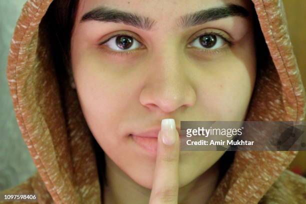 a teenager girl showing her artificial nails while putting her finger on lips - kid putting finger in mouth stock-fotos und bilder