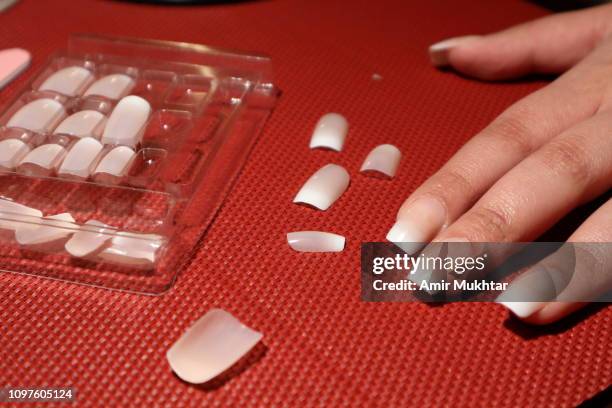 applying artificial nails for beauty purpose - künstlicher fingernagel stock-fotos und bilder