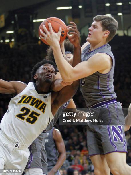 Forward Tyler Cook of the Iowa Hawkeyes battles for a rebound in the second half against forward Miller Kopp and center Barret Bensin of the...