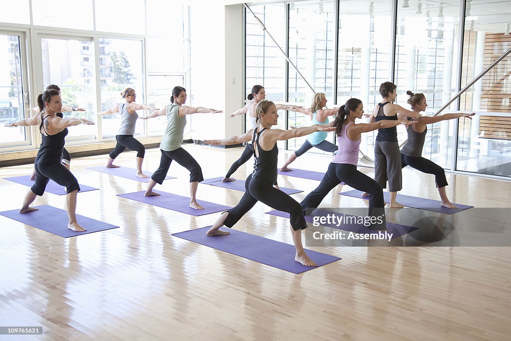Yoga instructor guiding class through poses