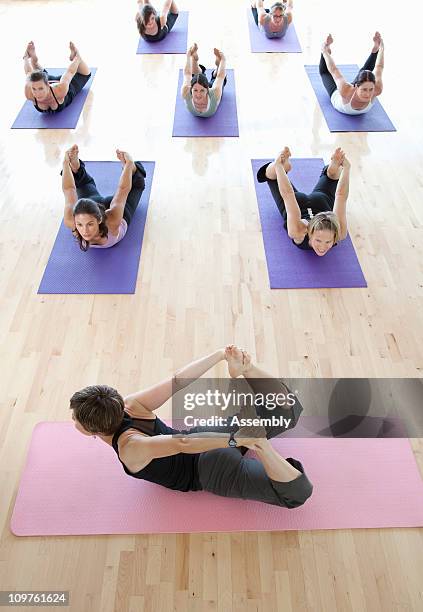 yoga instructor guiding class through pose - child yoga elevated view stock pictures, royalty-free photos & images