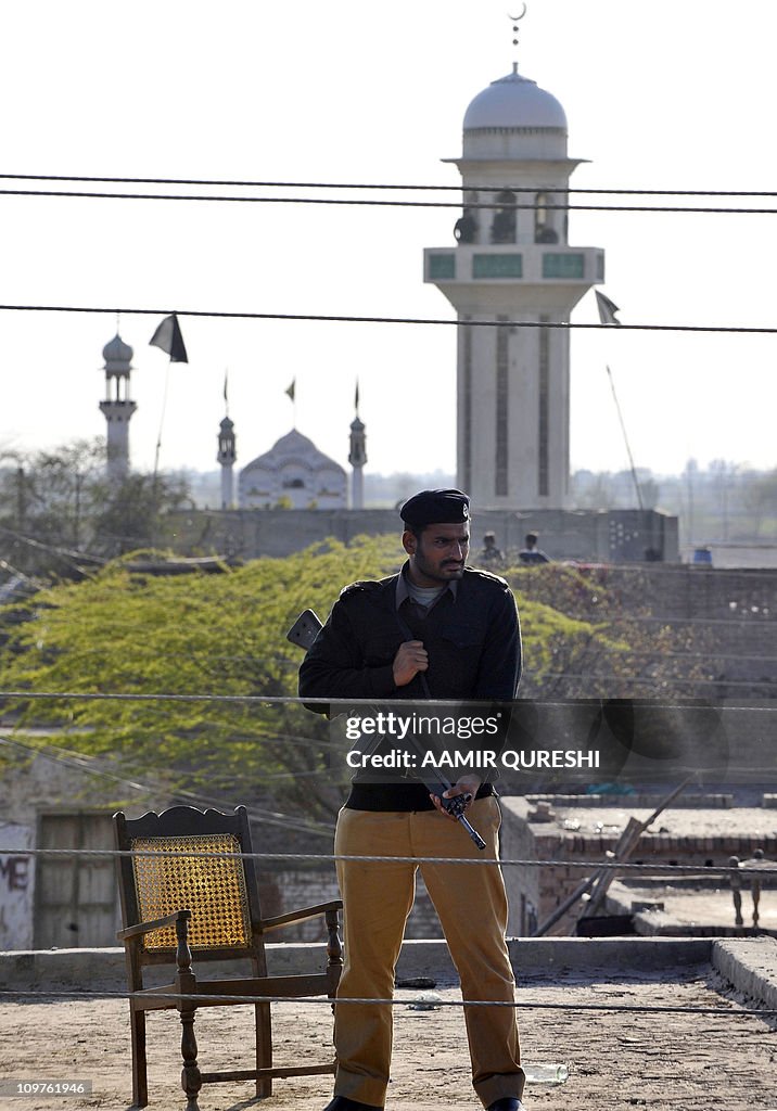 A Pakistani policeman stands guard besid