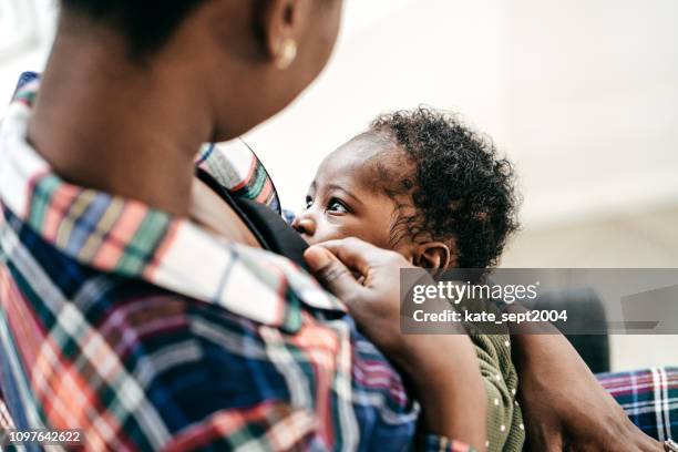 breastfeeding moment - black newborn stock pictures, royalty-free photos & images