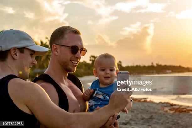 homosexual godparents and their young nephew - cuba beach stock pictures, royalty-free photos & images