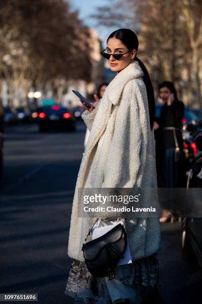 Fiona Zanetti, wearing a long white fur coat and black Dior bag, is seen outside Christian Dior during Paris Fashion Week - Haute Couture Spring...