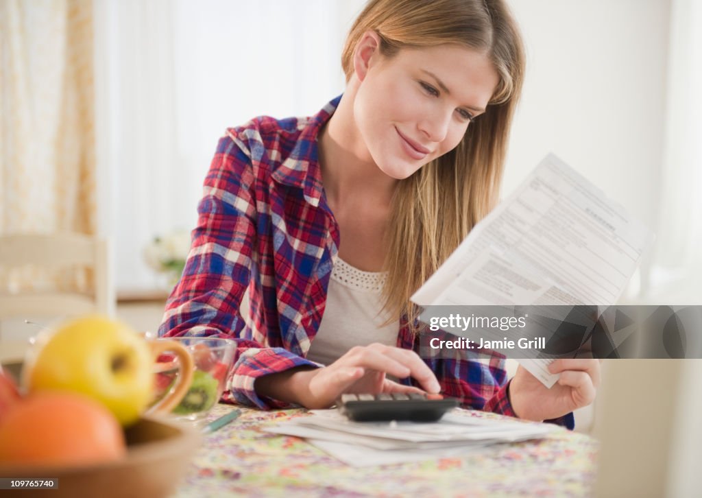 Woman going over bills with calculator