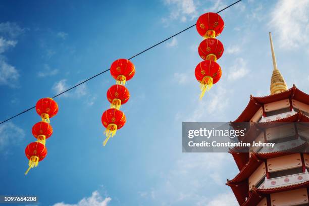 pagoda temple tower and red lanterns hanging against blue sky - 中国 提灯 ストックフォトと画像