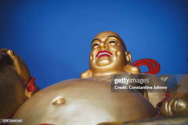 smiling buddha statue against blue hour sky at pu tuo si temple - buddha face stock-fotos und bilder