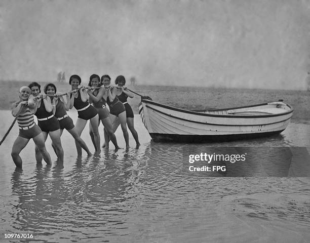 Group of women pulling their boat ashore in Le Touquet, France in 1930.