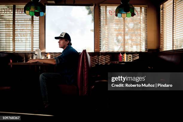 trucker waiting for service in a diner - un solo hombre fotografías e imágenes de stock