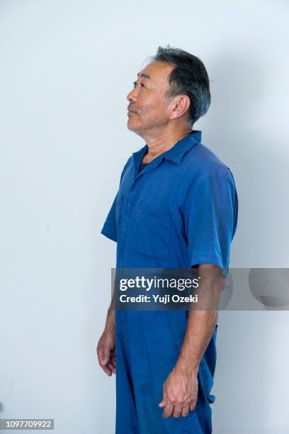 a man with a blue working clothes - blue jumpsuit foto e immagini stock