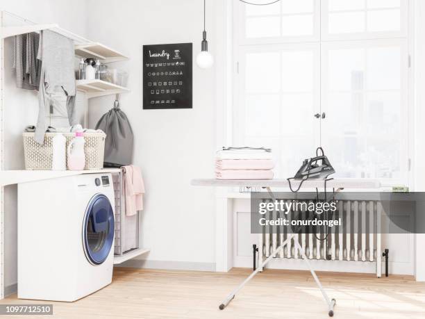 waschküche mit waschmaschine und bügeleisen - hauswirtschaftsraum stock-fotos und bilder