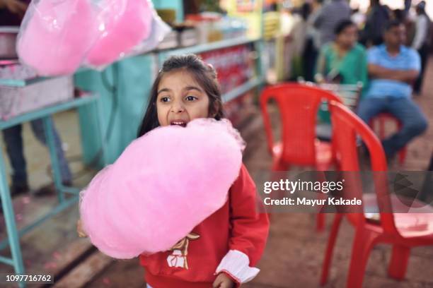 young girl (4-5 years) eating cotton candy - candyfloss stock pictures, royalty-free photos & images
