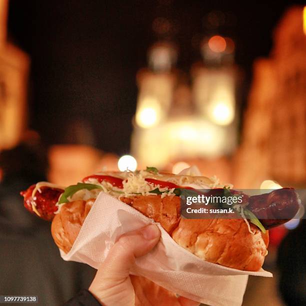 hand holding hotdog at christmas market. - prague food photos et images de collection